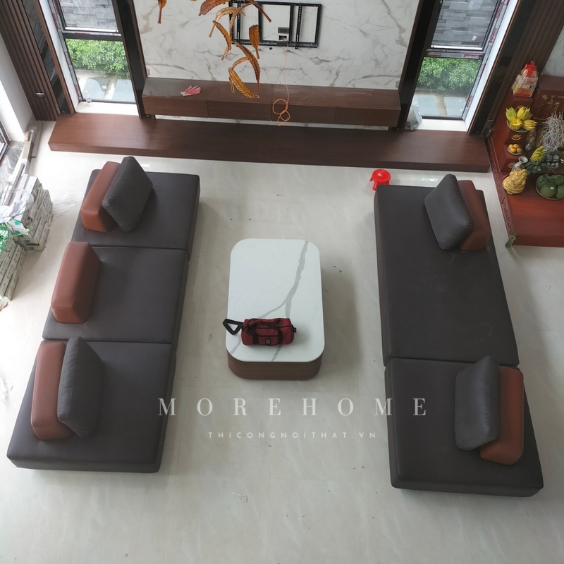 Thi công bộ sofa văng dài bọc da màu nâu hiện đại có diện tích rộng, thoải mái cho sử dụng.